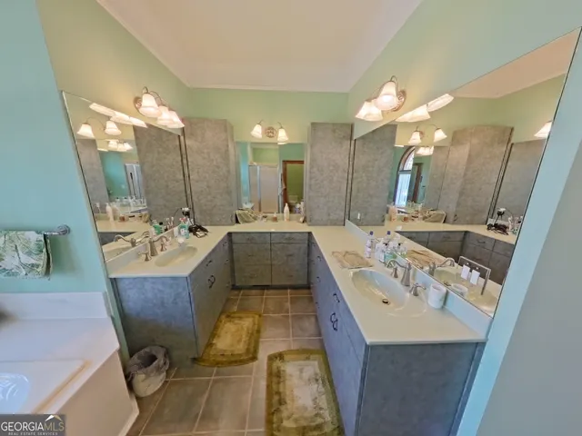 a bathroom with a granite countertop sink a bathtub and a window