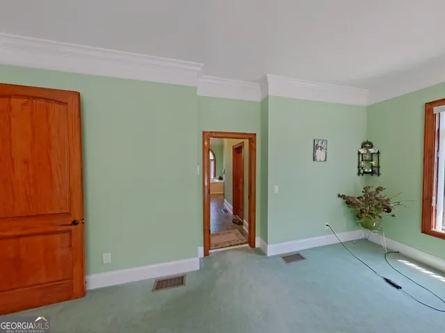 a spacious bedroom with a bed a chandelier and large window