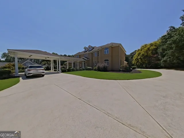 a big house with tall trees in the background