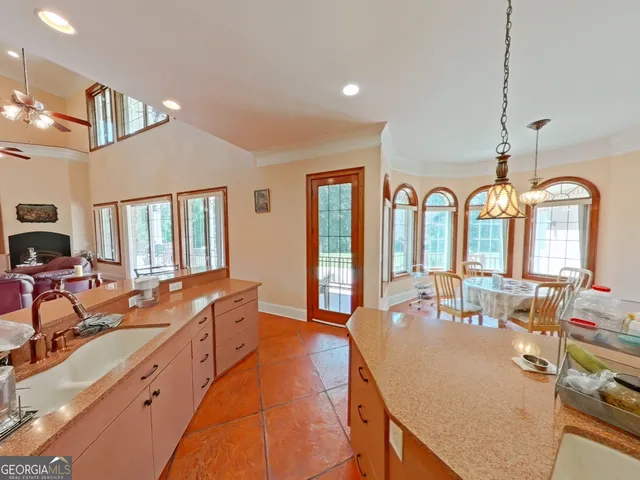 a large living room with stainless steel appliances granite countertop furniture a fireplace and a large window