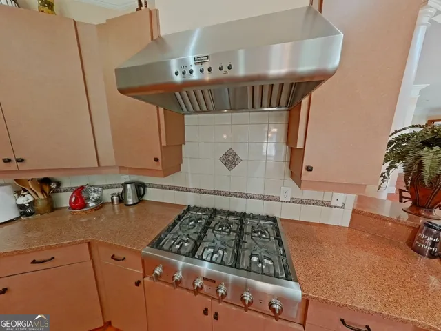 a view of kitchen sink with stove and cabinets