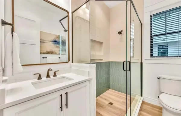 a bathroom with a sink a mirror a toilet and shower