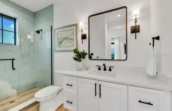 a bathroom with a granite countertop sink a toilet and shower