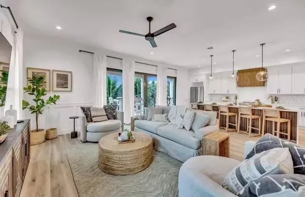 a living room with furniture kitchen and a chandelier
