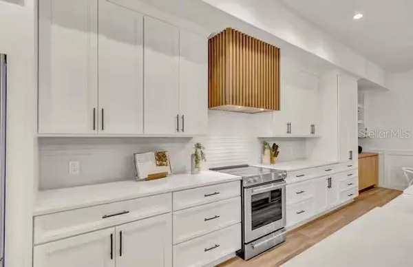 a kitchen with granite countertop white cabinets and white appliances