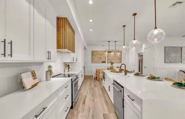 a kitchen with kitchen island granite countertop a sink a counter space and stainless steel appliances