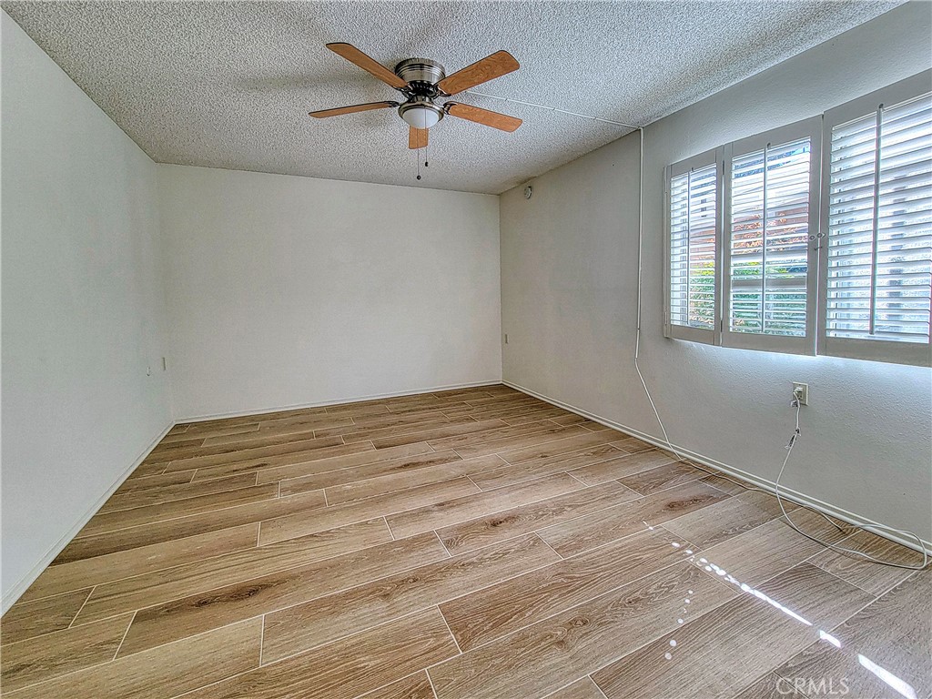 3370 Punta Alta, Unit C Laguna Woods, CA 92637 - Photo 14 of 29 a view of empty room with wooden floor and fan