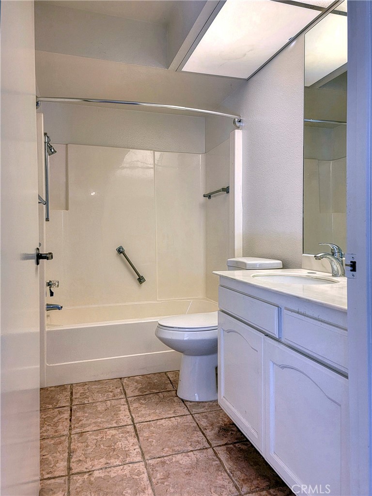 3370 Punta Alta, Unit C Laguna Woods, CA 92637 - Photo 16 of 29 a bathroom with a granite countertop toilet a sink and bathtub