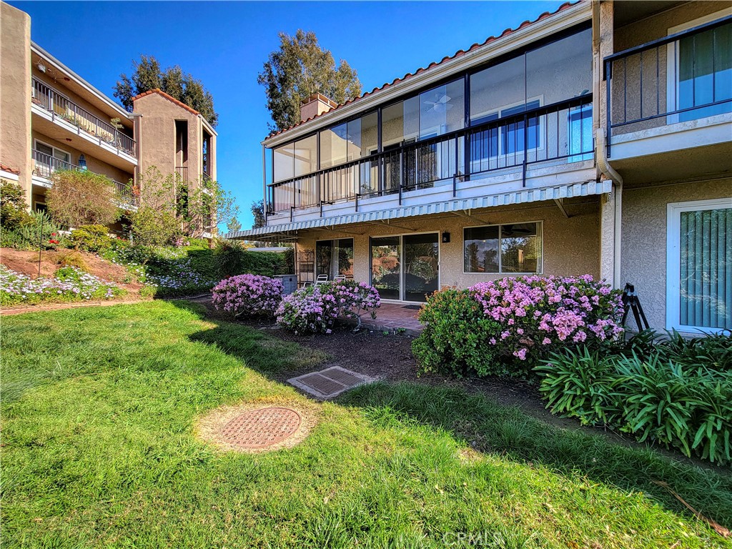 3370 Punta Alta, Unit C Laguna Woods, CA 92637 - Photo 26 of 29 a front view of a house with a garden and plants