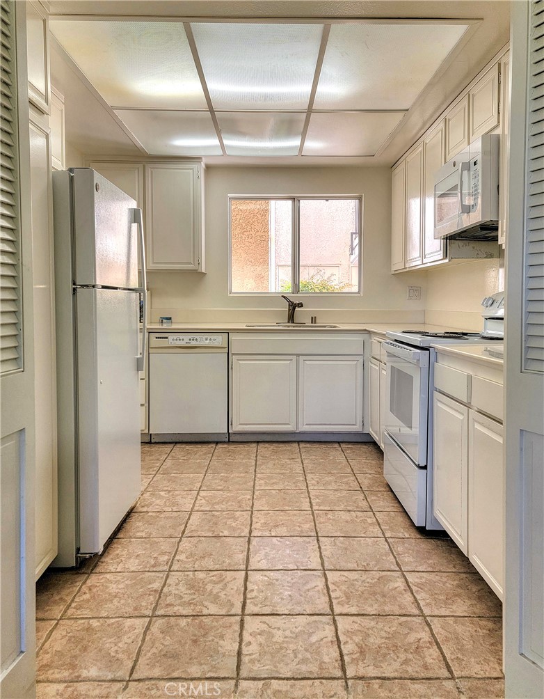 3370 Punta Alta, Unit C Laguna Woods, CA 92637 - Photo 10 of 29 a kitchen with stainless steel appliances a sink and a refrigerator