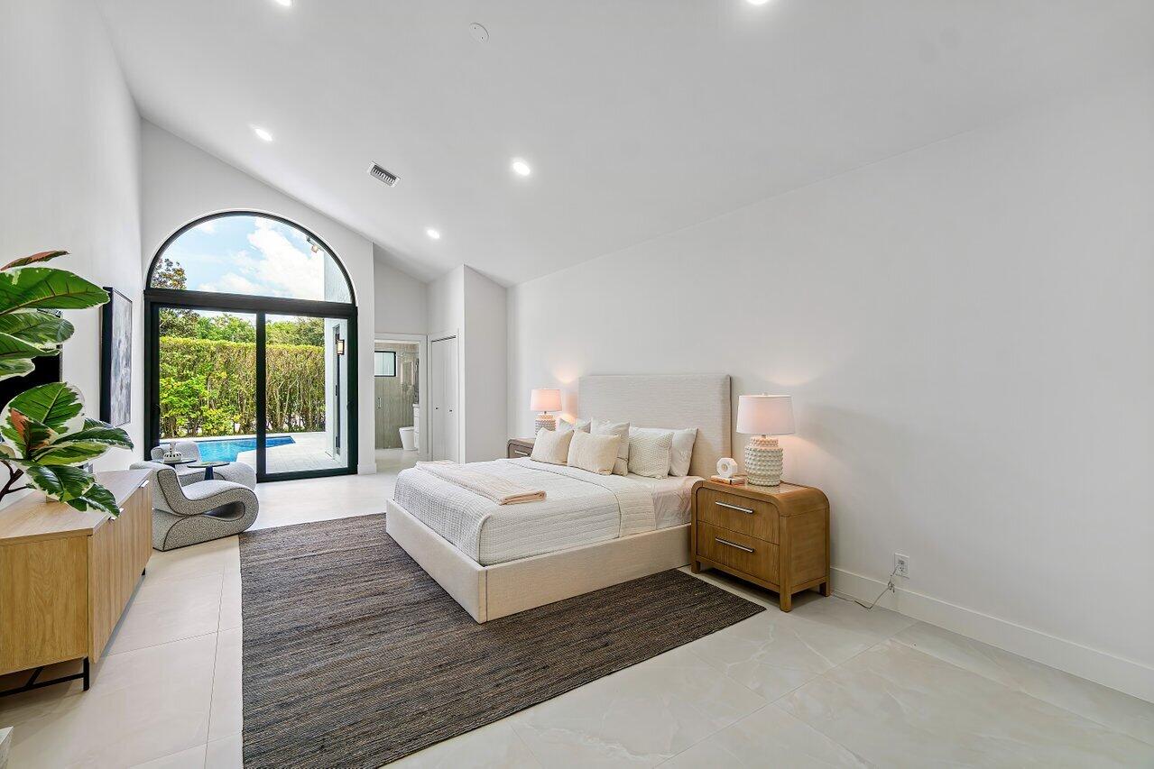 5529 Steeple Chase Boca Raton, FL 33496 - Photo 13 of 56 a spacious bedroom with a bed and a large window
