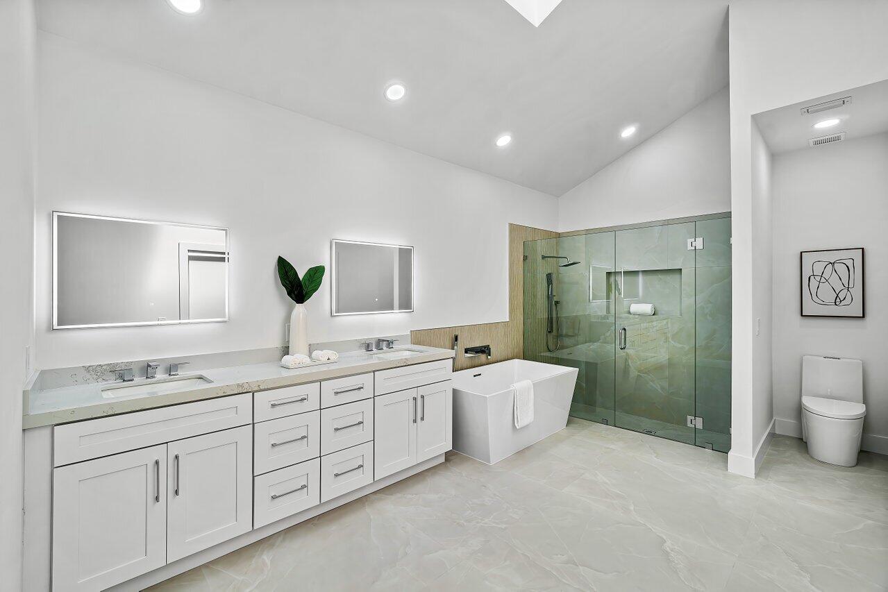 5529 Steeple Chase Boca Raton, FL 33496 - Photo 17 of 56 a spacious bathroom with a double vanity sink a large mirror and a