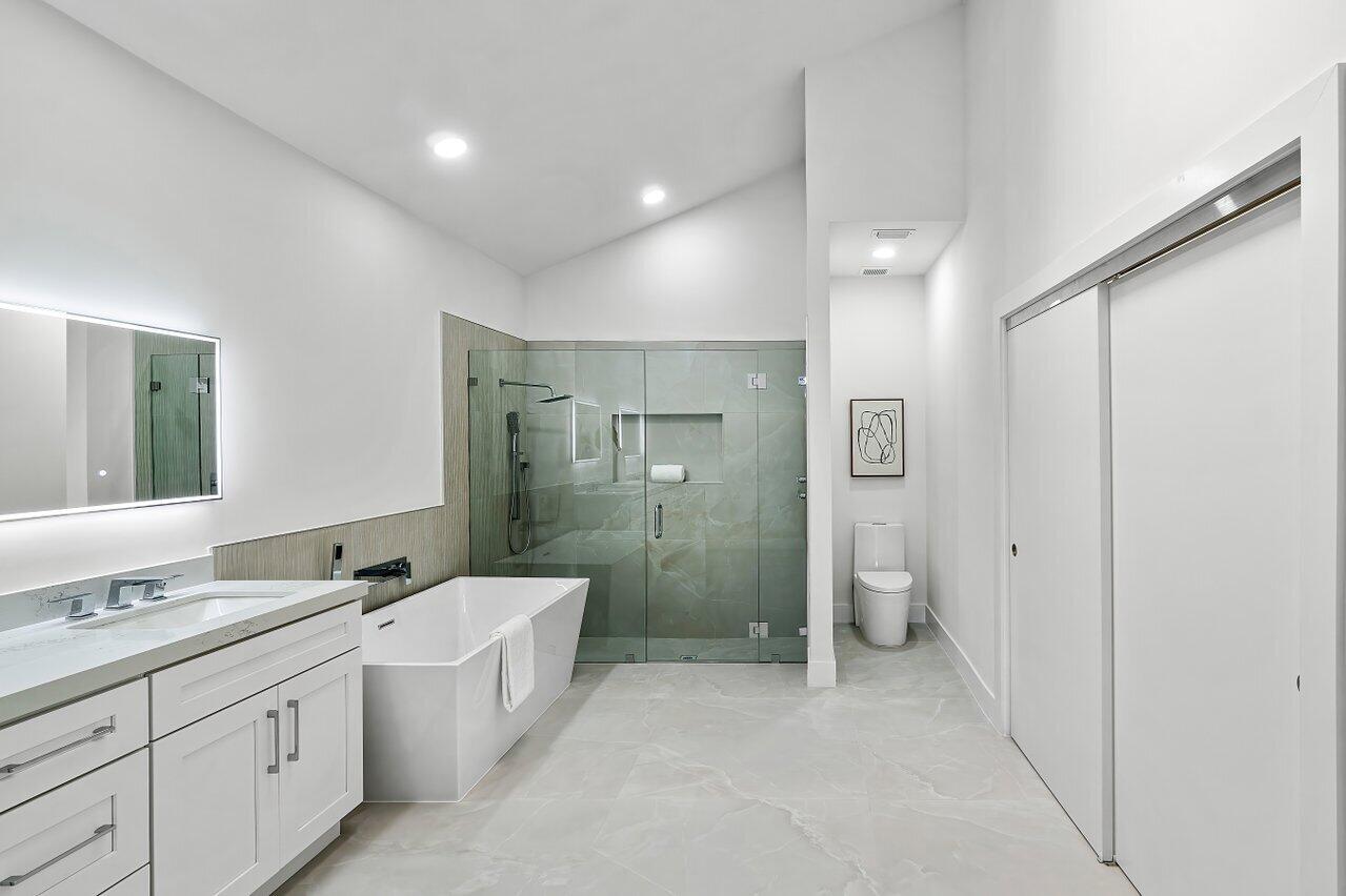 5529 Steeple Chase Boca Raton, FL 33496 - Photo 18 of 56 a bathroom with a double vanity sink toilet mirror and shower