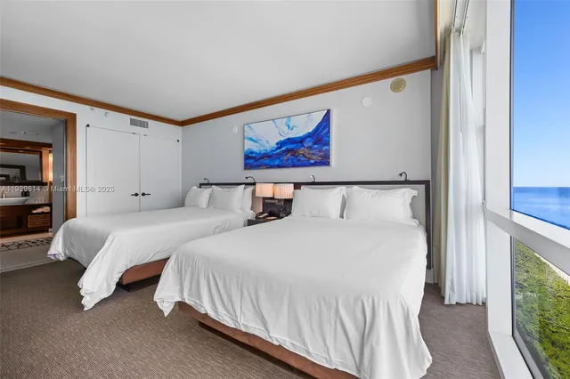 a bedroom with two beds and a large window