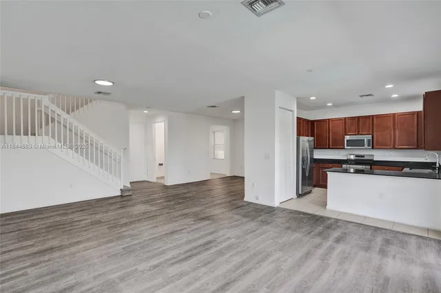 a kitchen with stainless steel appliances granite countertop a stove a refrigerator a sink and a microwave