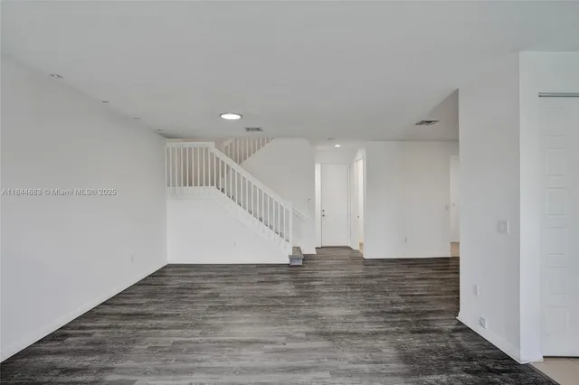 a kitchen with kitchen island granite countertop wooden cabinets a refrigerator and a sink