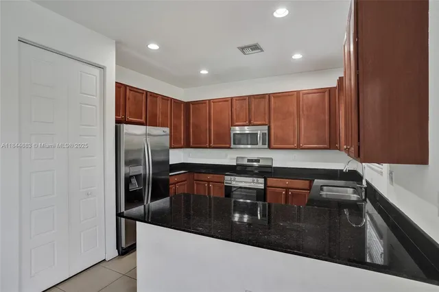a kitchen with granite countertop stainless steel appliances sink microwave and stove
