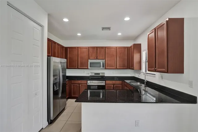 a kitchen with granite countertop a sink and a window