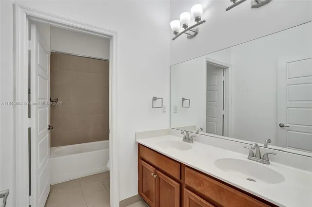 a bathroom with a granite countertop sink a large mirror and a bathtub