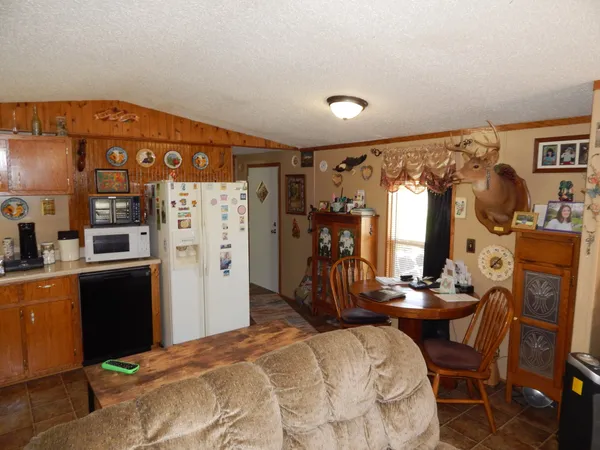 a spacious bedroom with a bed and a view of kitchen