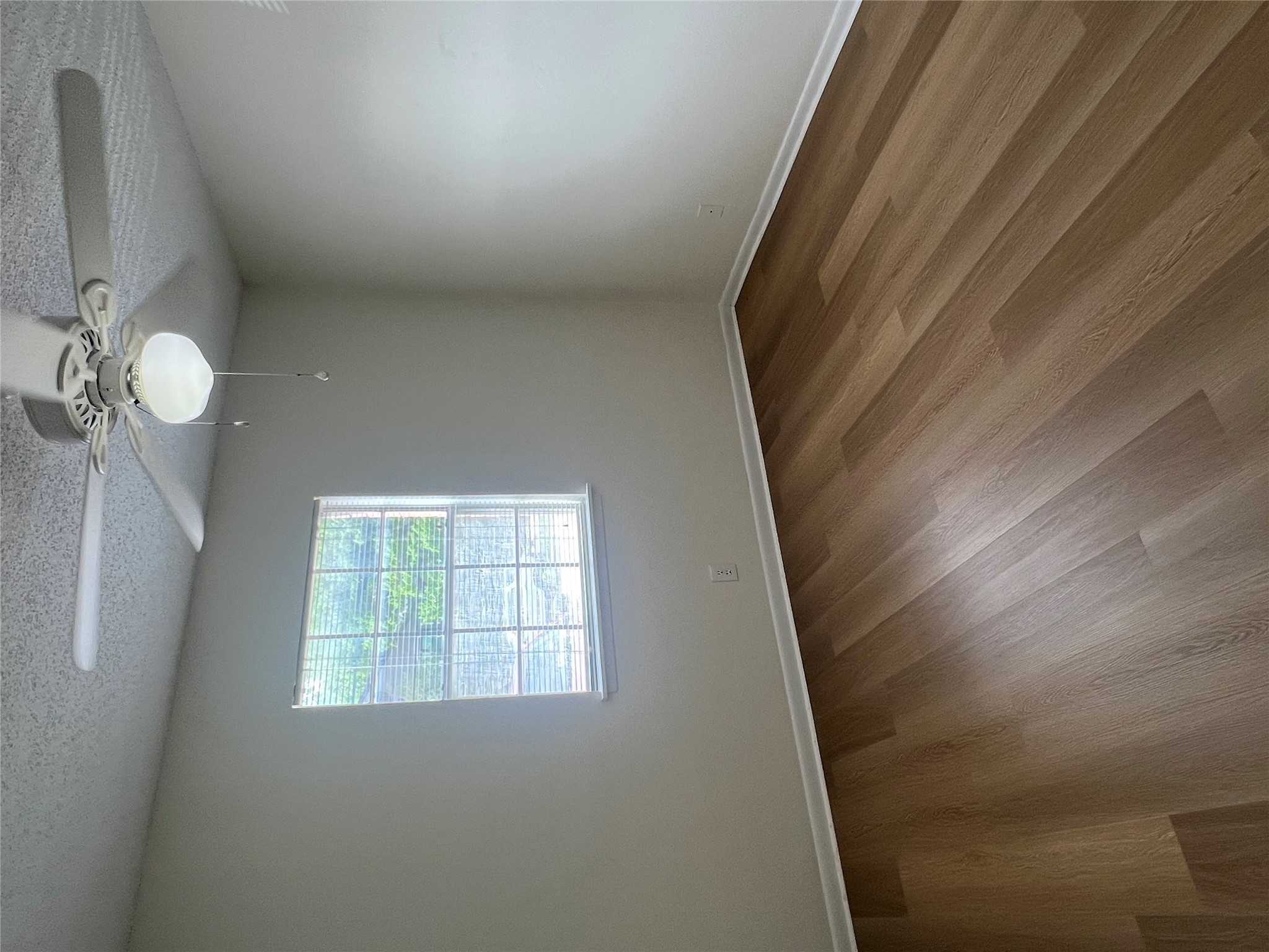1410 West N Loop Boulevard, Unit 102 Austin, TX 78756 - Photo 21 of 24 an empty room with wooden floor chandelier fan and window
