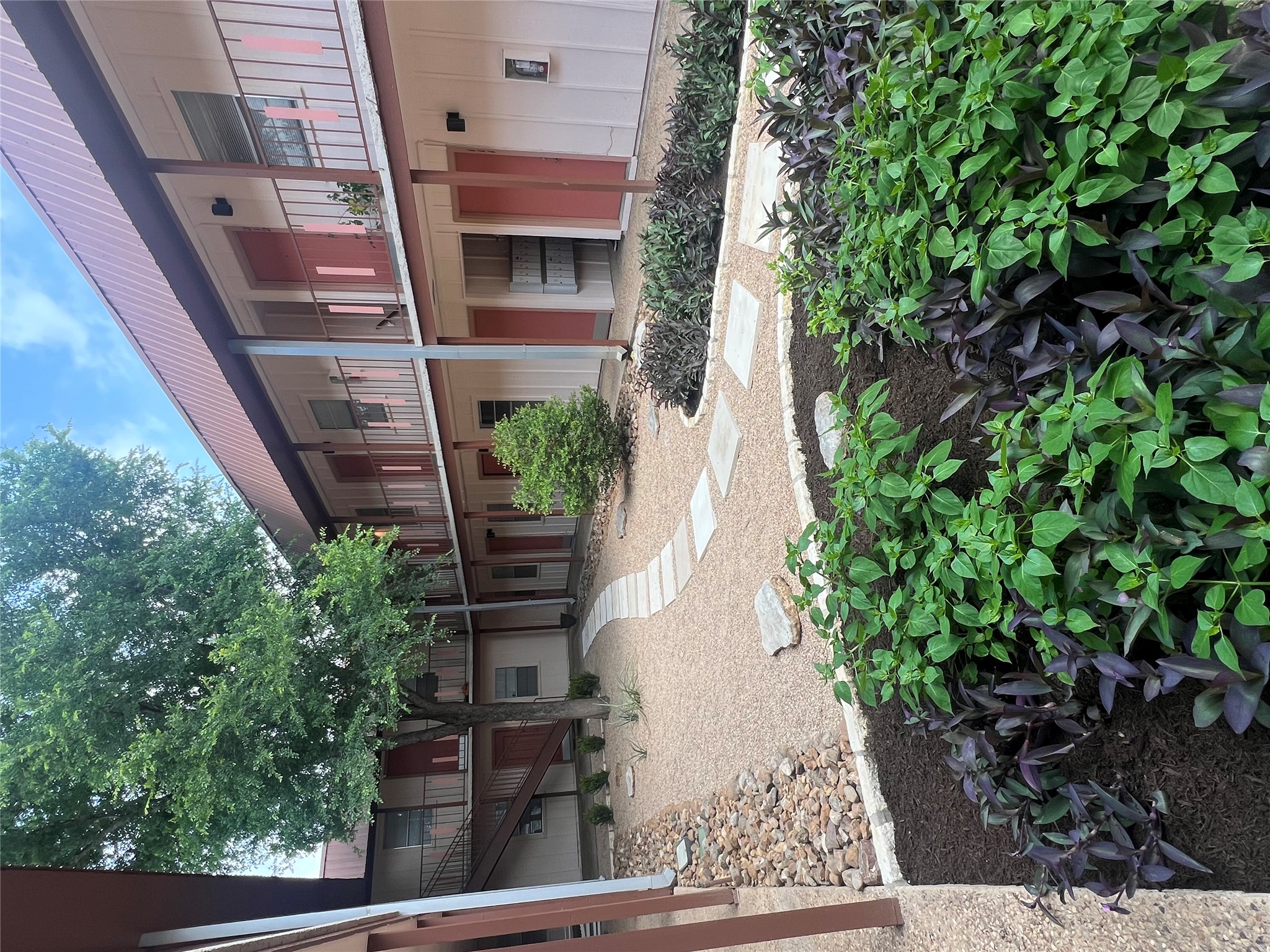 1410 West N Loop Boulevard, Unit 102 Austin, TX 78756 - Photo 6 of 24 a front view of a house with a yard and outdoor seating