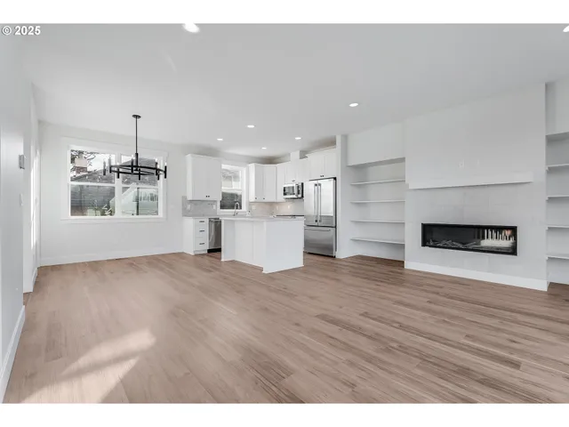 a view of a kitchen with a refrigerator a stove top oven and cabinets