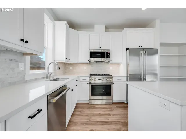 a kitchen with stainless steel appliances a stove sink and refrigerator