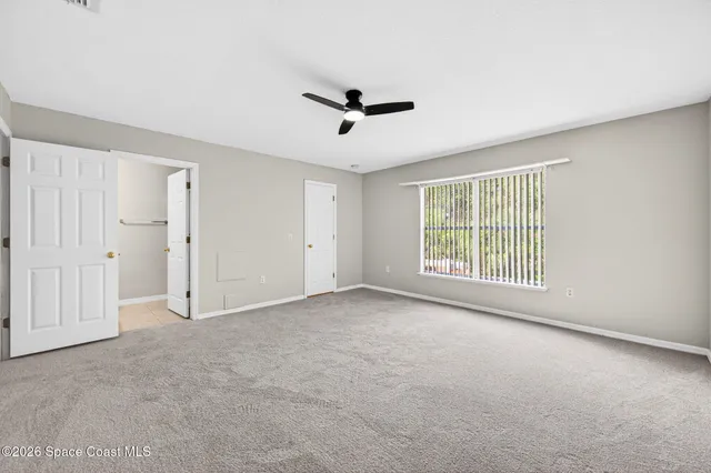 a spacious bedroom with a bed and a potted plant