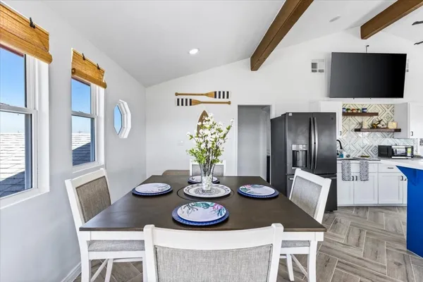 a kitchen with stainless steel appliances granite countertop a dining table and chairs