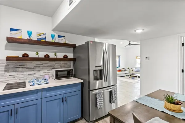 a kitchen with stainless steel appliances a refrigerator and wooden floor
