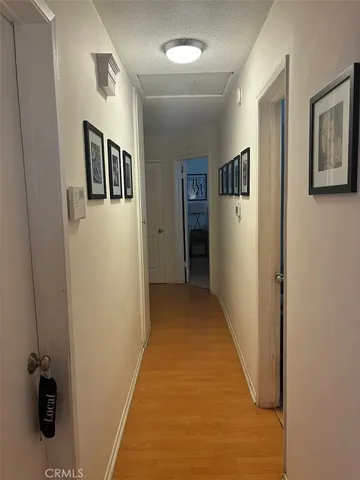 a view of a hallway with closet and wooden floor