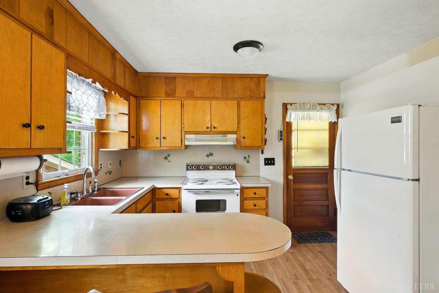 112 Hillside Road Hurt, VA 24563 - Photo 9 of 39 a kitchen that has a refrigerator a stove and a sink with large windows