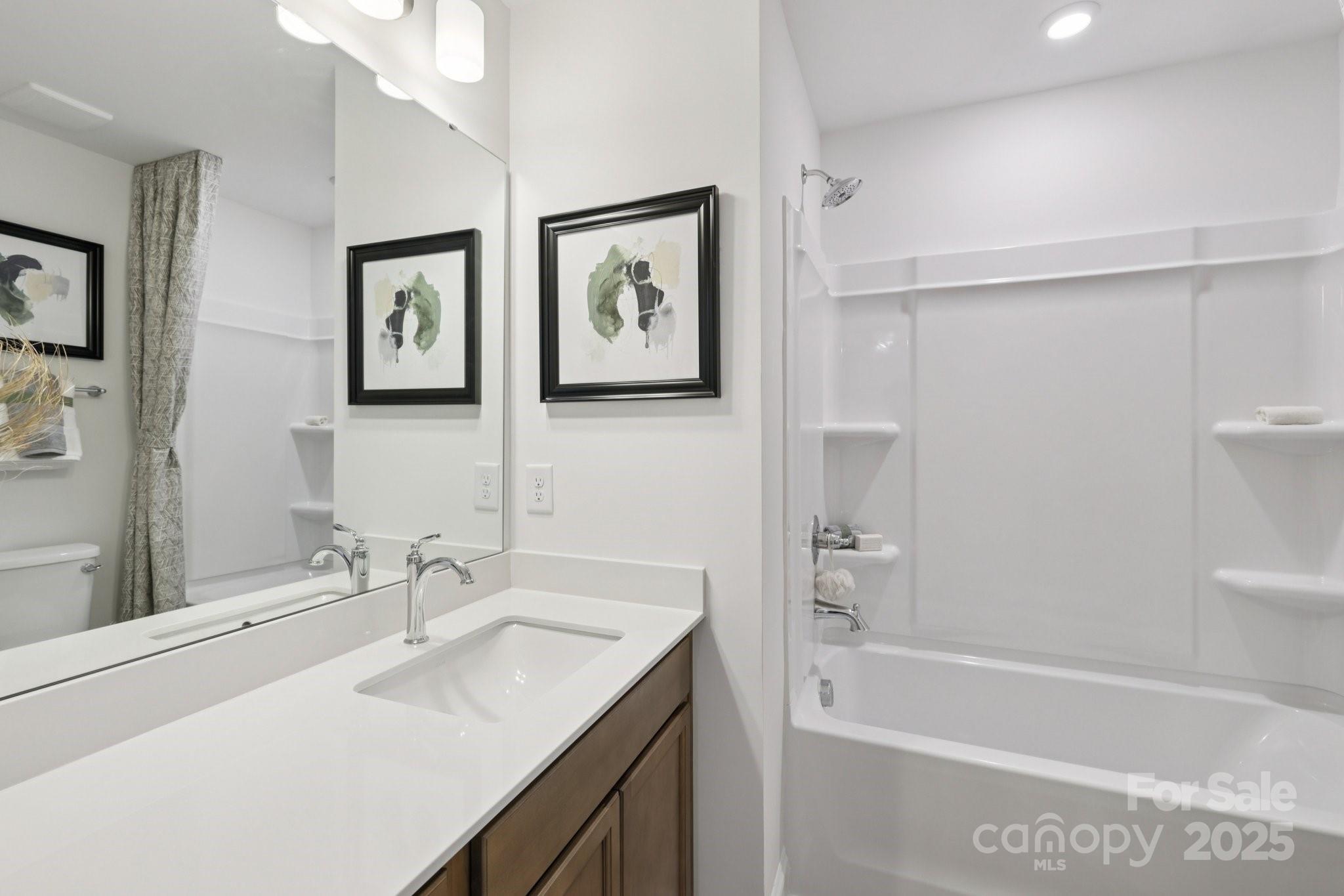 7717 Ethora Way Charlotte, NC 28216 - Photo 8 of 24 a bathroom with a tub a sink and mirror