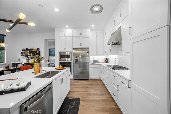 a kitchen with white cabinets sink and stainless steel appliances