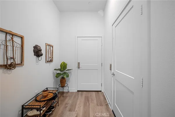 a view of a hallway with wooden floor and furniture