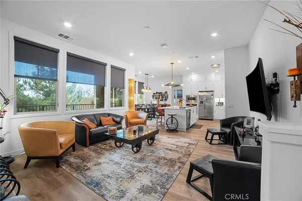 a living room with furniture flat screen tv and large window