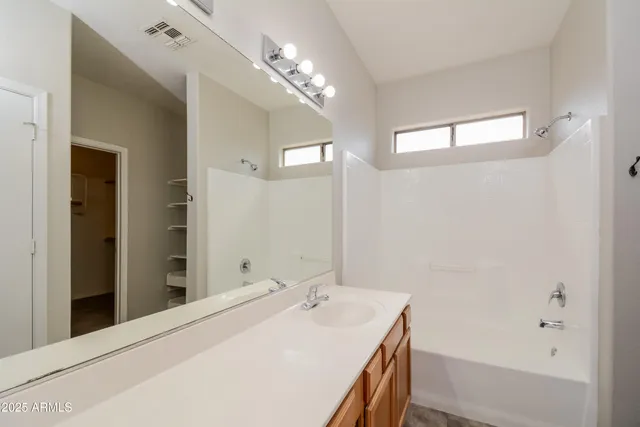 a bathroom with a tub sink and mirror