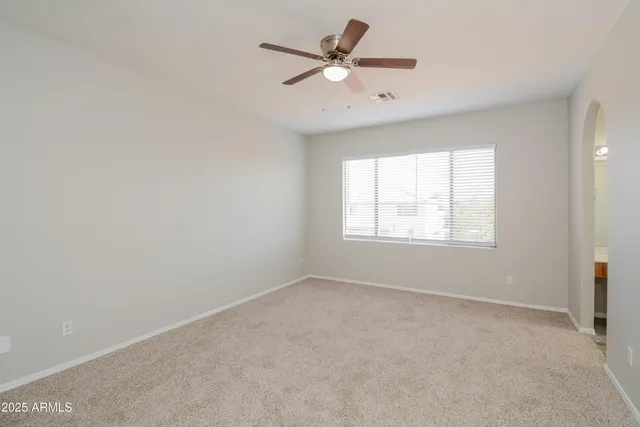 an empty room with a window and a fan