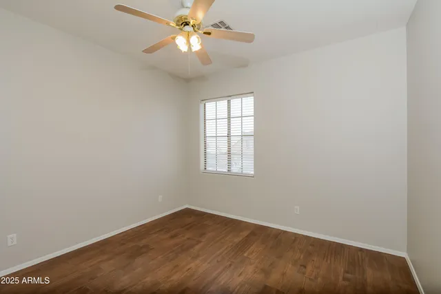 an empty room with a window and a fan