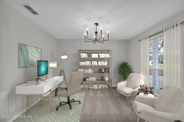 a view of an empty room with furniture and chandelier