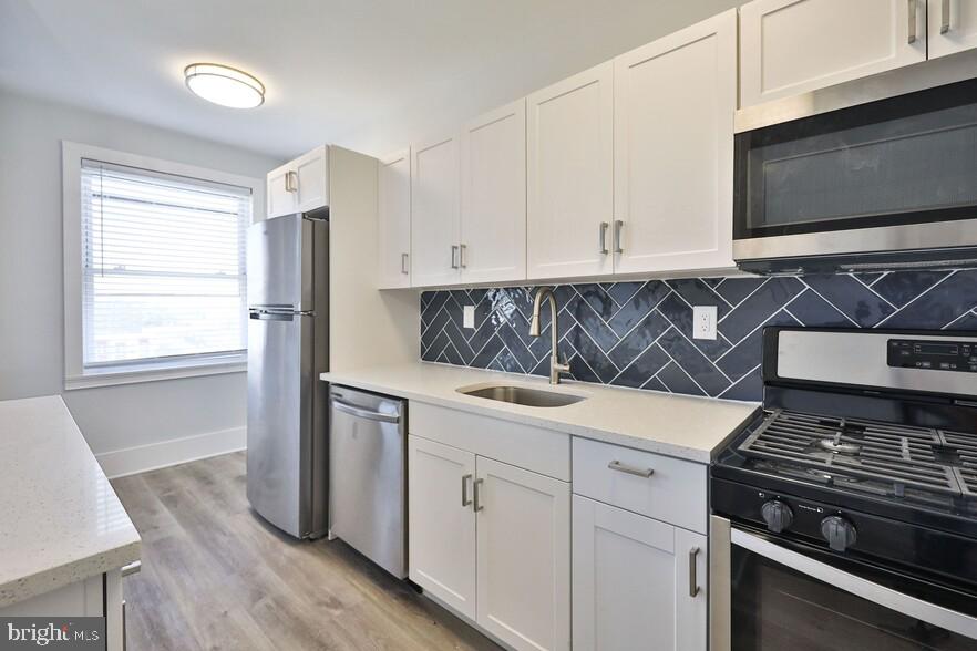 4247 Locust Street, Unit 1B714 Philadelphia, PA 19104 - Photo 1 of 38 a kitchen with stainless steel appliances white cabinets and a stove top oven
