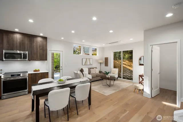 a kitchen with a refrigerator a stove a microwave oven with a dining table and chairs