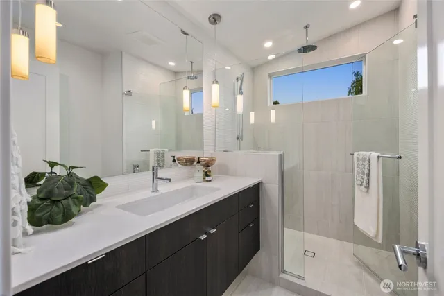 a bathroom with a double vanity sink mirror and shower