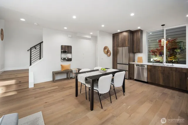 a living room with furniture potted plant and kitchen view