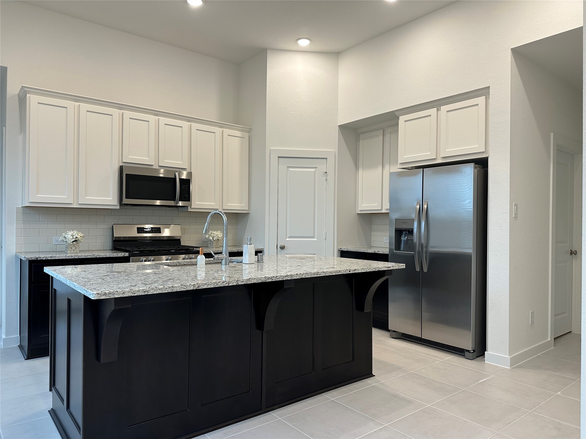 5115 Murillo Drive Manvel, TX 77578 - Photo 12 of 31 a kitchen with stainless steel appliances granite countertop a refrigerator a sink a stove a microwave and wooden cabinets
