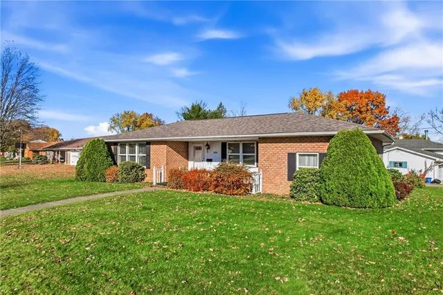 a front view of a house with a garden and yard