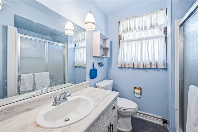 a bathroom with a sink a toilet and shower