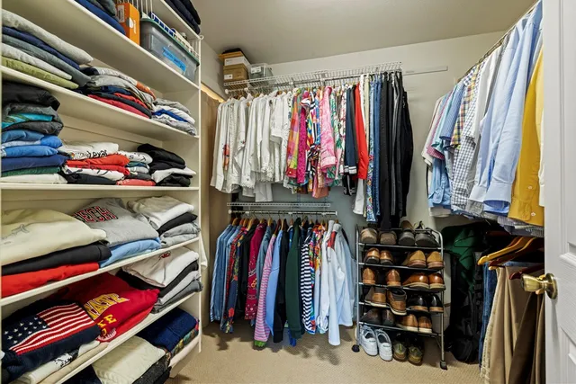 a view of walk in closet with clothes