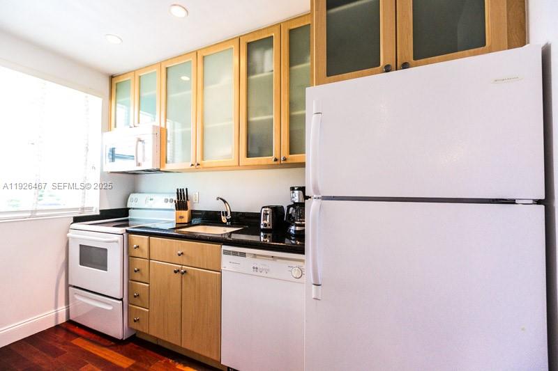 420 15th Street, Unit 106 Miami Beach, FL 33139 - Photo 4 of 9 a kitchen with a white cabinets and a refrigerator